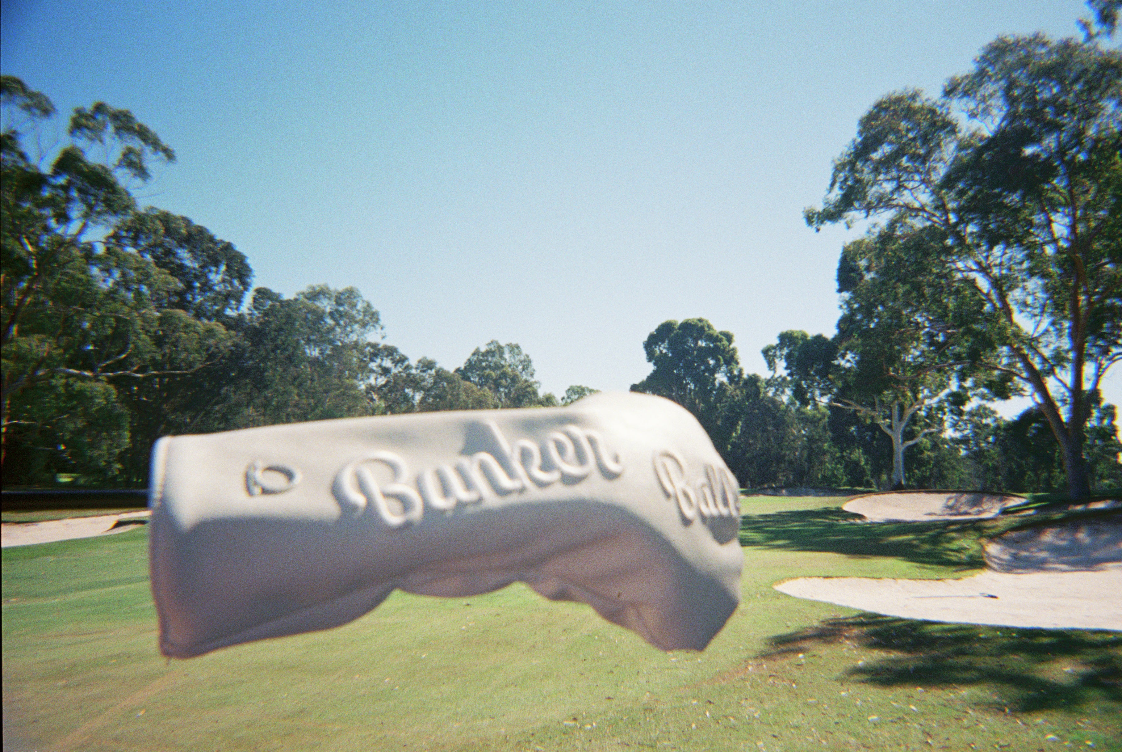 Golf Headcover with 'Bunker Ball' branding on a golf course