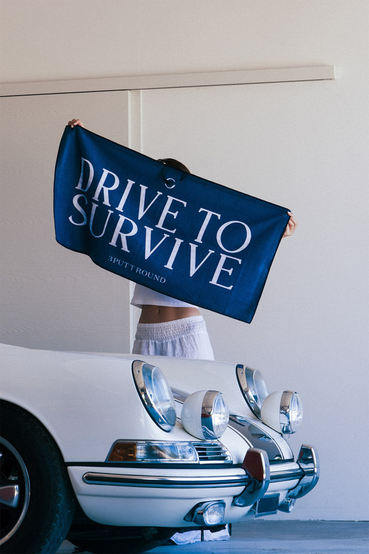 Three Putt Round Drive To Survive Tour Towel, soft and absorbent, with racing-themed design, ideal for sports and travel use.